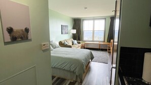 Una habitación de hotel con cama, sofá, mesa de comedor y zona de cocina.