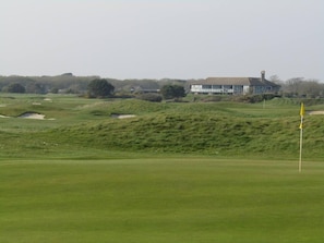 A golf course with a clubhouse in the background.