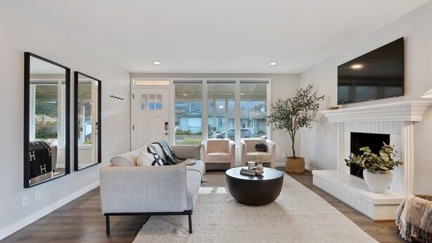 A modern living room with a sofa, armchairs, a coffee table, and a fireplace. - Marbella Lane - 3BR Designer Home in Pacifica (Pacifica)