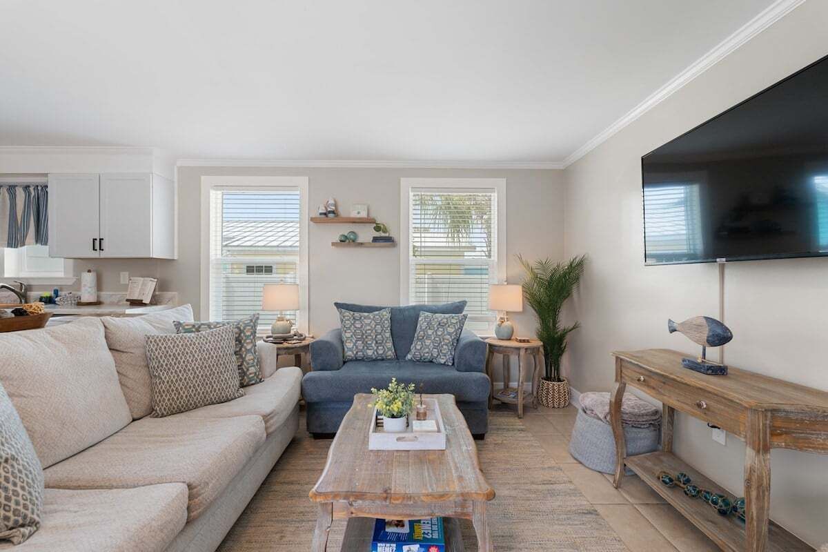 Ein Wohnzimmer mit einer Couch, einem Couchtisch, einem Fernseher und einem TV-Schrank.