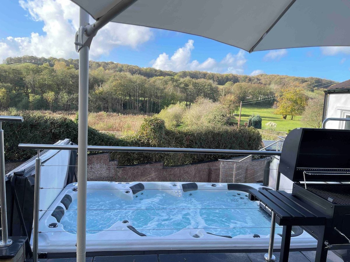 A hot tub with a view of a forested hillside.