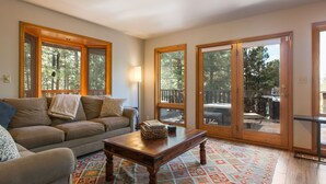A living room with a sofa, a coffee table, and a patterned rug. - Cabin Walkable to Lake with Hot Tub, Deck & Views, Pool Table, Near Golf & Bike (Angel Fire)