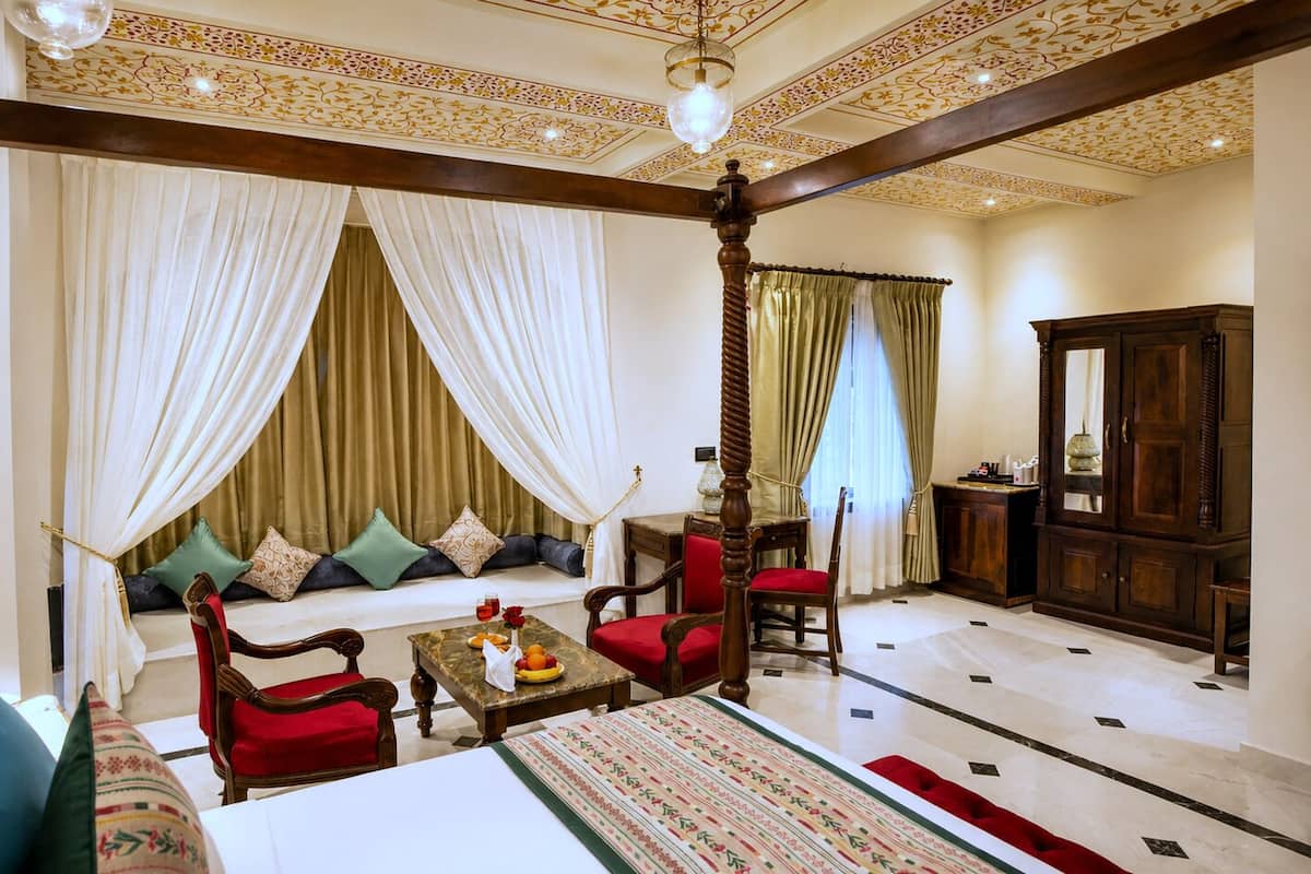 A room with a bed, a sofa, a coffee table, a chair, and a wooden cabinet.