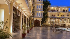 A hotel courtyard with tiled flooring, potted plants, outdoor seating, and a pool. - Amar Mahal Luxury Boutique Hotel Near Fateh Sagar Lake, Udaipur (Udaipur)