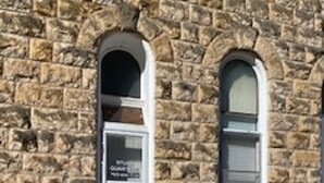 A stone building with a white door and arched windows. - Unique Space in Historic Building (Osborne)
