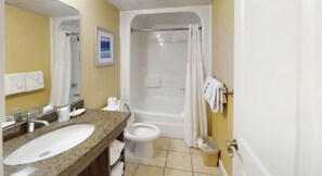 Un baño con lavamanos, inodoro, bañera y cortina de ducha.