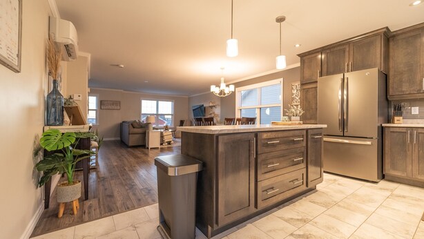 A modern kitchen with dark wood cabinets, stainless steel appliances, and a central island.