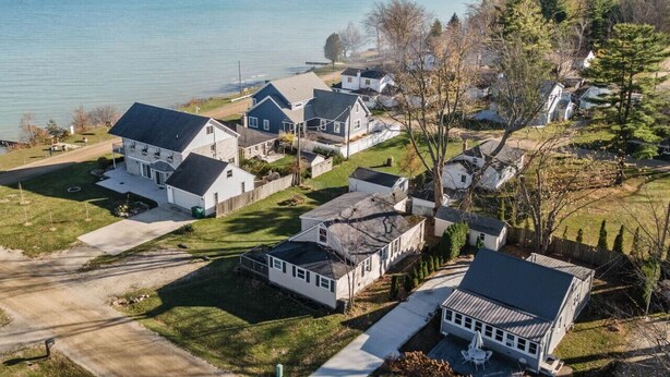 A residential area with houses, a driveway, and a body of water in the background. - LakeView Getaway: Lake views & hot tub! (Lexington)