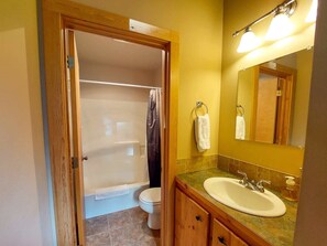 Bathtub, hair dryer, towels, shampoo