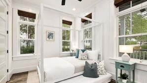 A bedroom with a white bed, multiple windows, and a small bedside table with a lamp. - Kid friendly home with golf cart, sports gear for beach pool lake  (Inlet Beach)