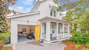 A white two-story house with a garage and a covered porch. - Kid friendly home with golf cart, sports gear for beach pool lake  (Inlet Beach)