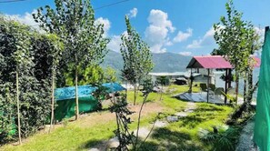 Escape to a serene natural setting surrounded by trees and a mountain range.