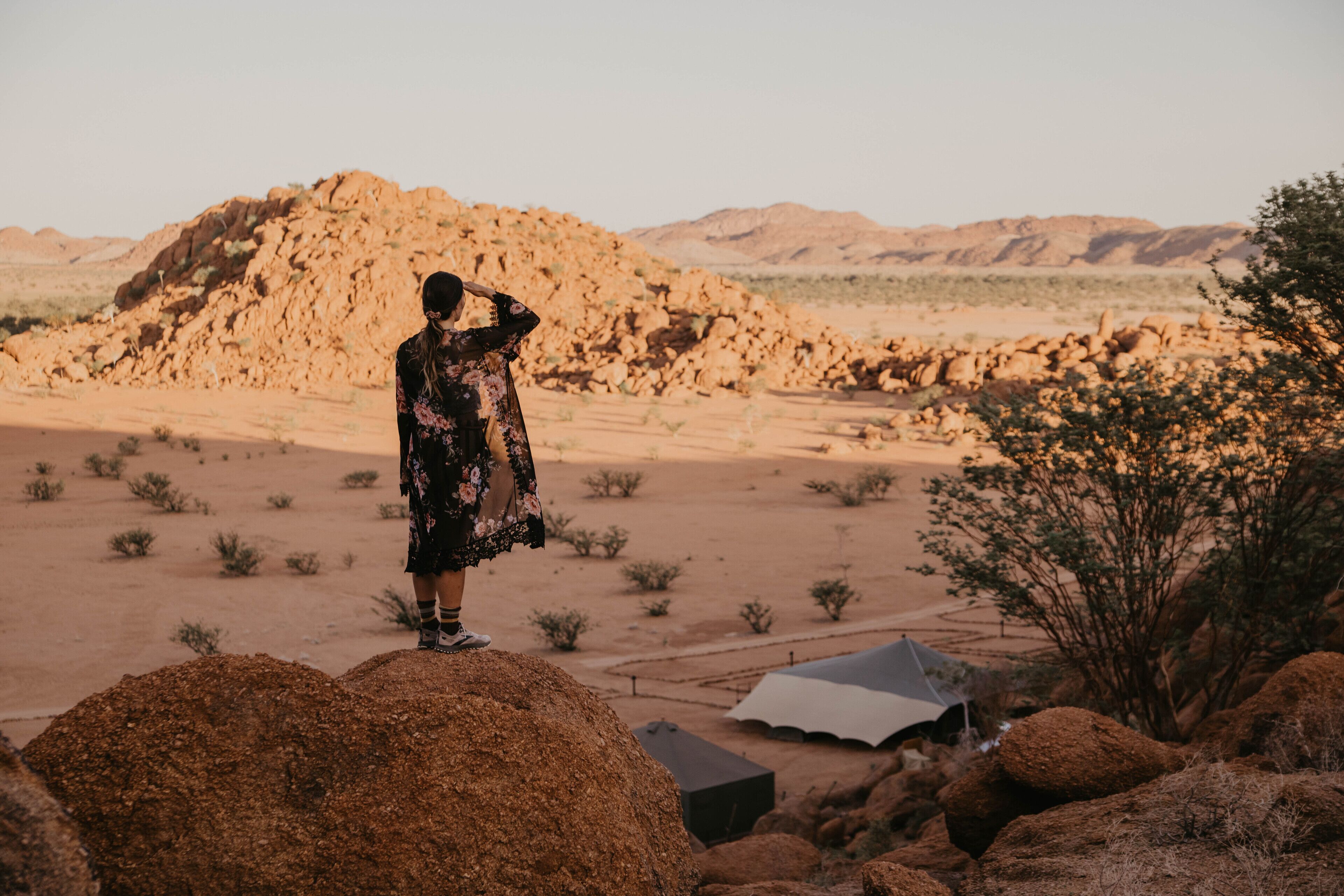 A desert landscape with a tent and rocky terrain.