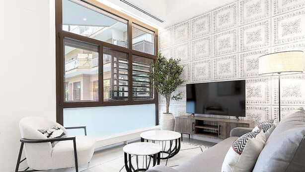 A modern living room with a large window, a flat-screen TV, a sofa, a chair, and a small table. - Genteel Home Atocha II (Madrid)