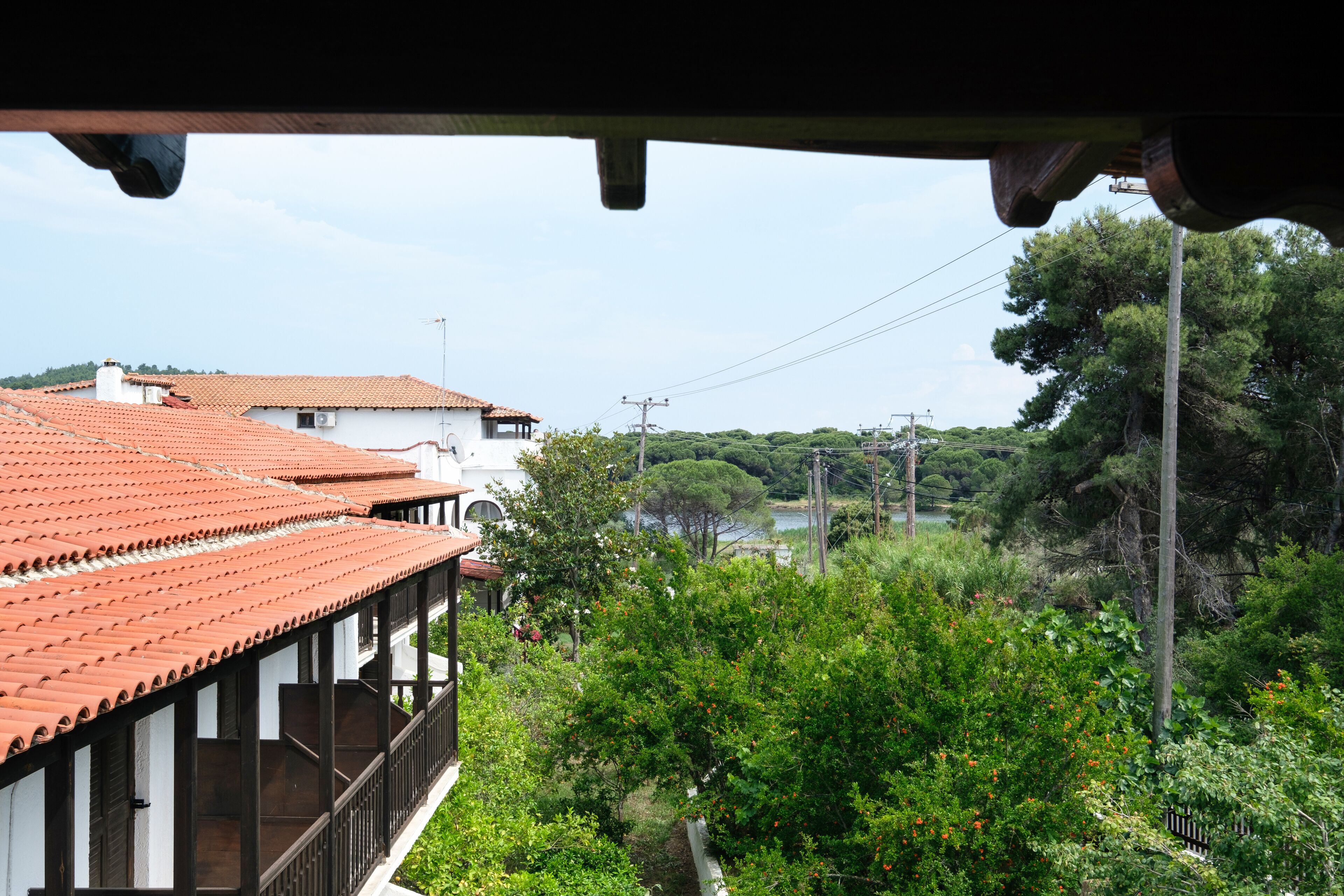 A view of a building with a red-tiled roof and a balcony.