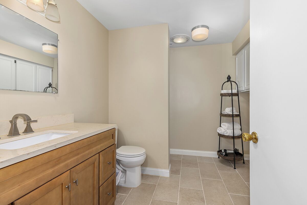 Une salle de bain équipée d’un lavabo, de toilettes et d’un porte-serviettes.