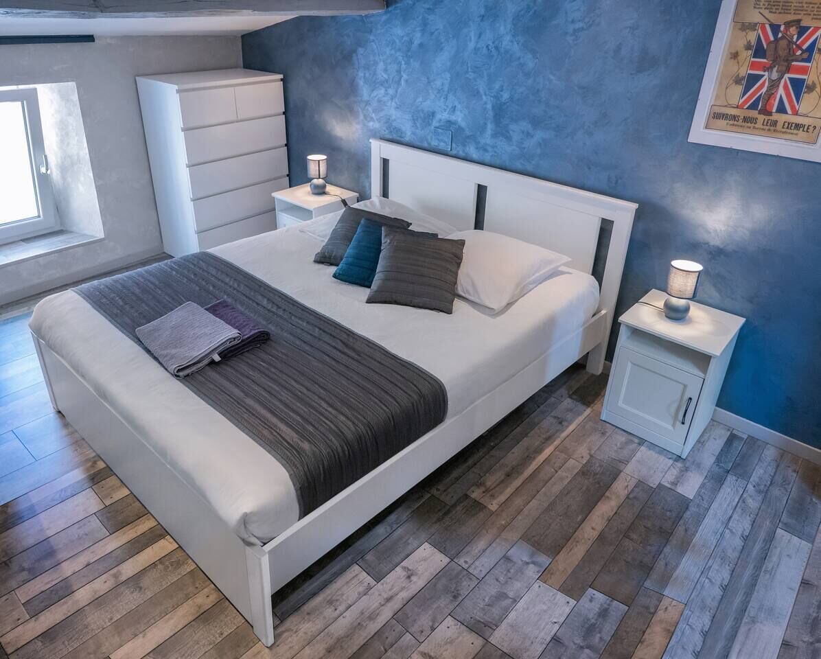 A modern bedroom with a bed, bedside tables, and a window.