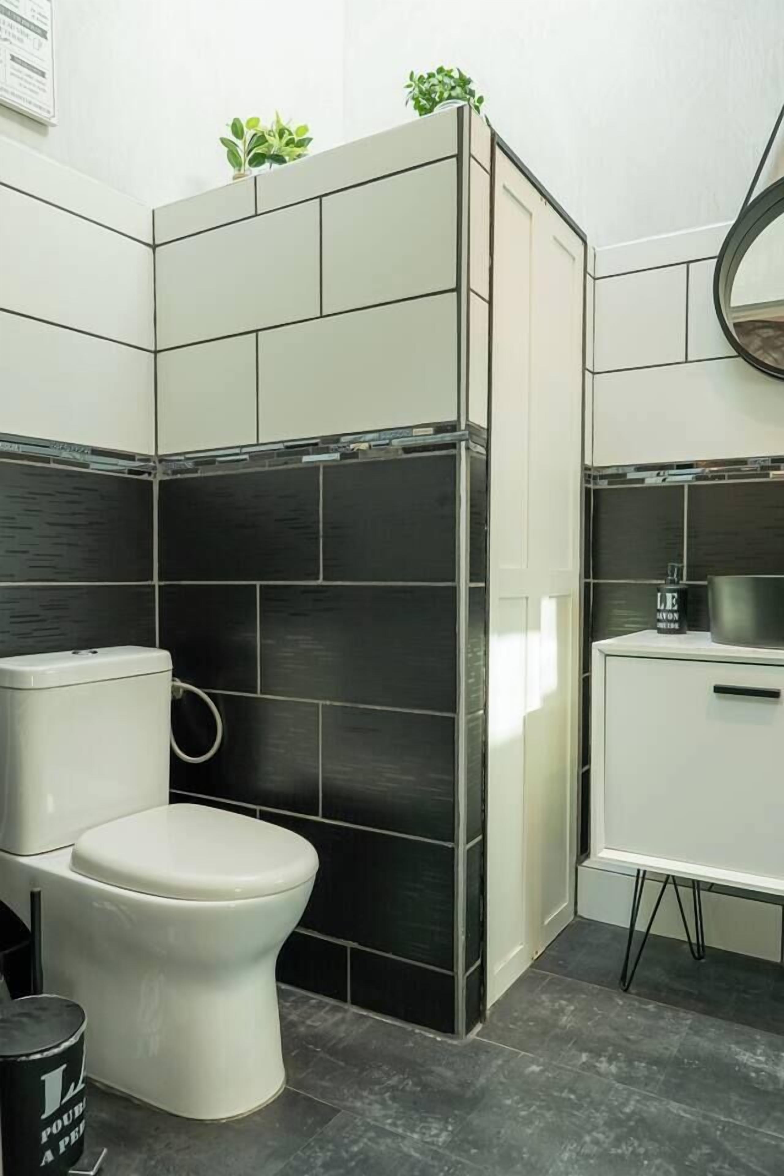 Un baño con inodoro, lavabo y zona de ducha.