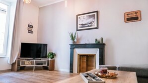 Ein Wohnzimmer mit Flachbildfernseher, Kamin, Couchtisch und Sofa.
