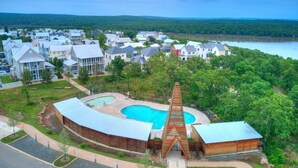 Un quartier résidentiel avec des maisons, une piscine et une grande structure en bois.