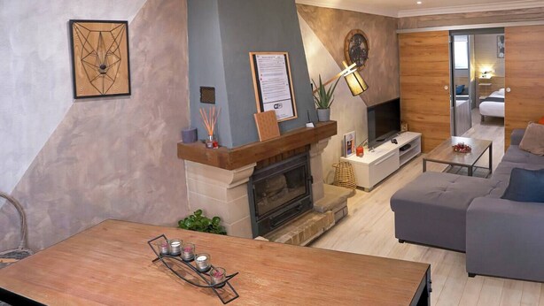 A modern living room with a fireplace, a sofa, a coffee table, and a TV.