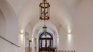 A spacious hallway with arched ceilings and a marble floor, leading to a wooden door at the end. - Hotel Nerudova 211 (Prague)