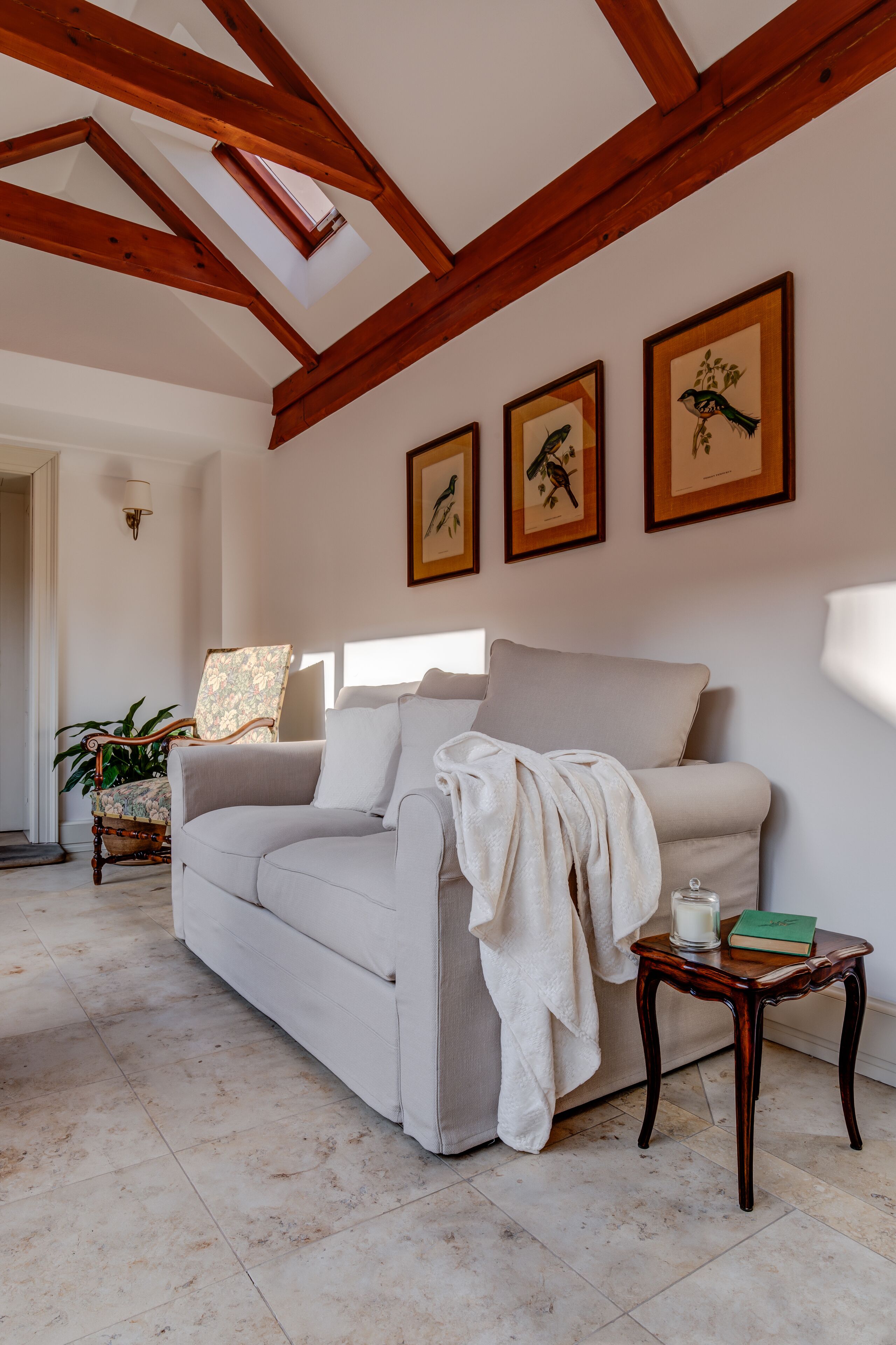 A living room with a beige sofa, a wooden coffee table, and framed artwork on the wall.