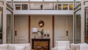 A spacious, elegantly furnished interior with a high ceiling and a glass atrium. - Hotel Nerudova 211 (Prague)