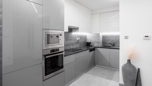 A modern kitchen with stainless steel appliances, a built-in oven, and a microwave. - Avand Apartments Debrecen (Debrecen)