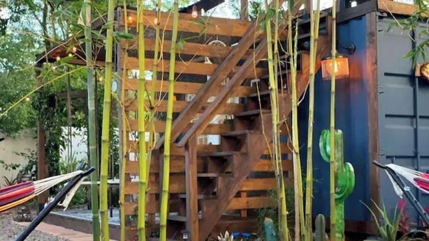 A fire pit with a wooden structure and cacti in the background. - Cozy AF Tiny-House Oasis (Tampa)