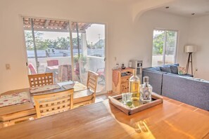 A dining area with a wooden table, chairs, and a tray with a bottle and glasses.