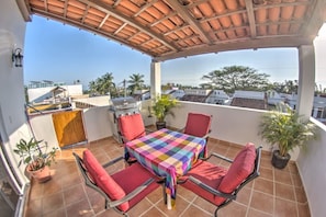 A covered outdoor patio with a table and chairs, a grill, and potted plants. - 1BR w Private Sunset Rooftop - Palmas 3A (Bucerías)