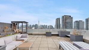 A rooftop terrace with outdoor seating, planters, and a city skyline view. - Spectacular Terrace - City/Lake View - 5 mins from major attractions (Toronto)