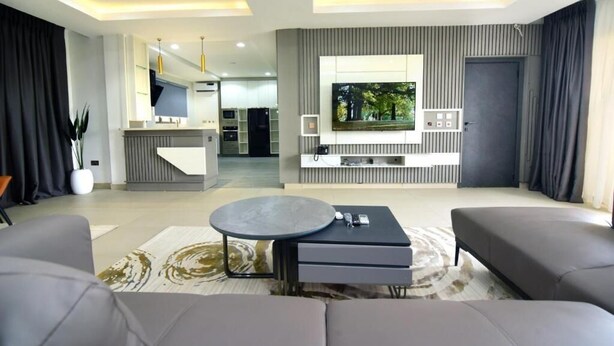 Una sala de estar moderna con un sofá, una mesa de centro y un televisor montado en la pared.
