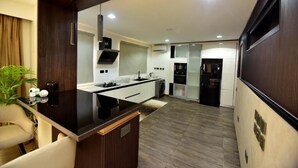 Una cocina moderna con una isla central, electrodomésticos integrados y una pared de madera oscura.