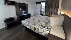A hotel room with a bed, a desk, a TV, and a window with curtains. - Motel 6 – Conway, SC (Conway)