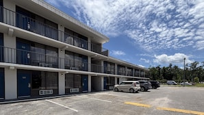 A multi-story motel with a parking lot. - Motel 6 – Conway, SC (Conway)