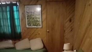 A room with a bed, a green sofa, a lamp, and a framed picture on the wall. - hermosa casa con piscina olmue (Olmue)