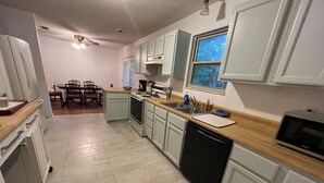 A kitchen with white cabinets, a dishwasher, a stove, and a window. - Cozy, Peaceful and Quiet Deerwood Cottage (Lake City)
