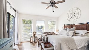 A bedroom with a bed, a bench, a dresser, and a ceiling fan. - The Lucky Minnow  • Pools, Hot Tub, Deck, Grill (Village of Four Seasons)