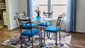 A dining area with a round table, four chairs, and a vase with flowers. - Lakefront Getaway |Private Dock + Free Kayaks (Bella Vista)