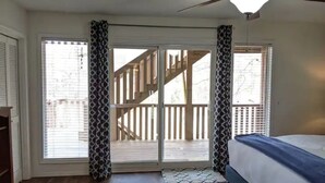 A bedroom with a bed, a ceiling fan, and a view of a wooden deck through a sliding glass door. - Lakefront Getaway |Private Dock + Free Kayaks (Bella Vista)