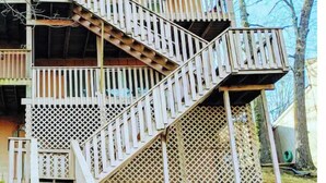 A multi-level wooden staircase leading to a balcony with a lattice railing. - Lakefront Getaway |Private Dock + Free Kayaks (Bella Vista)