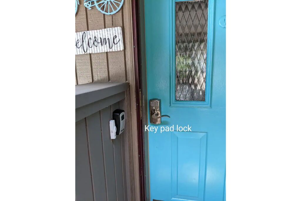 A blue door with a key pad lock and a welcome sign above it.