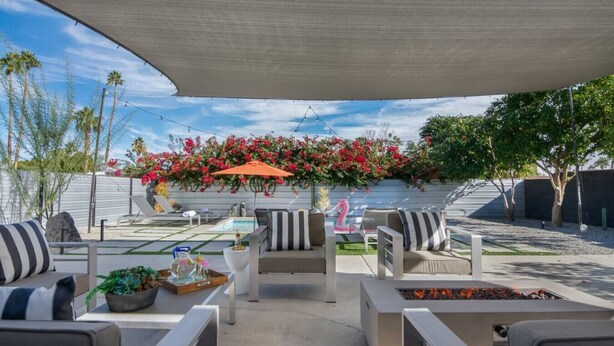 Une terrasse extérieure avec des sièges, un foyer et un espace piscine.
