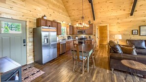 Ein geräumiges Blockhaus-Interieur mit Küche, Essbereich und Wohnzimmer.