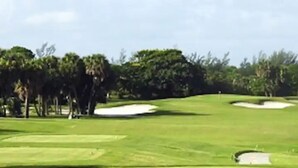 Un parcours de golf avec des bunkers de sable et des arbres.