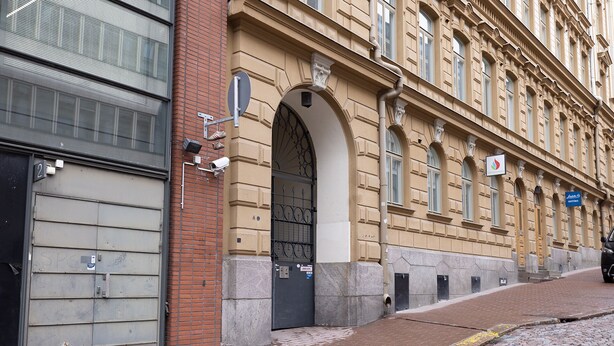 A historic building with a large arched entrance, a brick facade, and a cobblestone street. - 2ndhomes Central 1BR Apartment w Balcony (Helsinki)