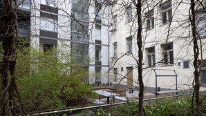 A view of a residential building with multiple balconies, surrounded by greenery and trees. - 2ndhomes Central 1BR Apartment w Balcony (Helsinki)