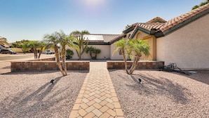 A paved pathway leading to a building with a tiled roof and a landscaped area with palm trees. - Gilbert Family Home: Games, Private Pool & Patio! (Gilbert)